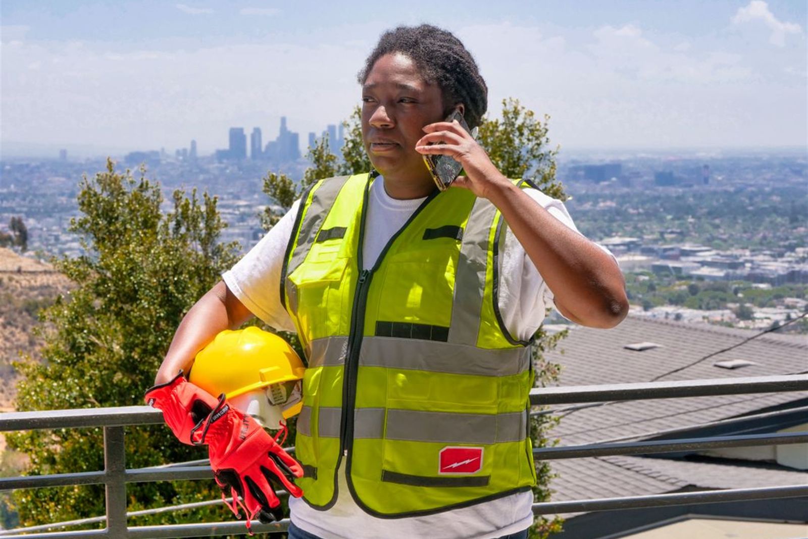 Mine safety worker in hi-vis using a phone on site to scan a QR code and report a hazard